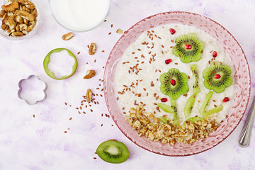 Tasty and healthy oatmeal porridge with kiwi, pomegranate and nuts. Healthy breakfast. Fitness food. Proper nutrition. Top view