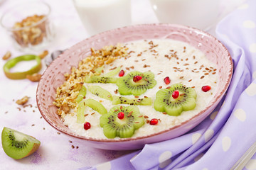 Tasty and healthy oatmeal porridge with kiwi, pomegranate and nuts. Healthy breakfast. Fitness food. Proper nutrition.
