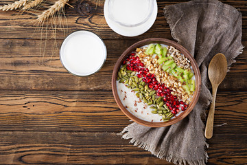 Delicious and healthy oatmeal with kiwi, pomegranate and seeds. Healthy breakfast. Fitness food. Proper nutrition. Rustic style. Flat lay. Top view