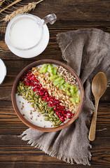 Delicious and healthy oatmeal with kiwi, pomegranate and seeds. Healthy breakfast. Fitness food. Proper nutrition. Rustic style. Flat lay. Top view