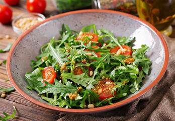 Dietary menu. Vegan cuisine. Healthy salad with arugula, tomatoes and pine nuts.