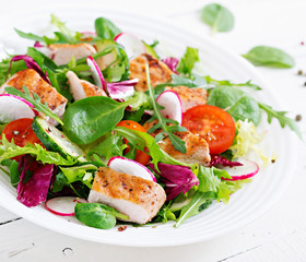Fresh vegetable salad with grilled chicken breast   - tomatoes, cucumbers, radish and mix lettuce leaves. Chicken salad. Healthy food.