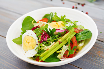 Delicious and light salad of tomatoes, eggs and a mix of lettuce leaves. Healthy breakfast.