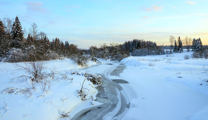 Frosty winter landscape with frozen river.Beautiful view.Twilight.Cold morning.Snow covered trees.Sunrise.River Torgosha in Moscow region,Russia.