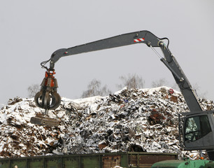 The hydraulic grab cleans and tampens the metal debris. The excavator lifts and throws the load with a pneumatic paw with claws.