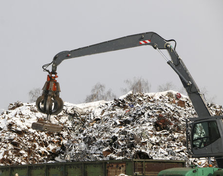 The hydraulic grab cleans and tampens the metal debris. The excavator lifts and throws the load with a pneumatic paw with claws.