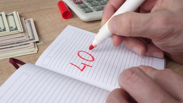 Man writing 401k in a note. Retirement plan concept.
