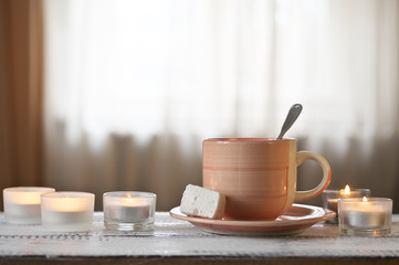 Cup of cocoa and burning candles