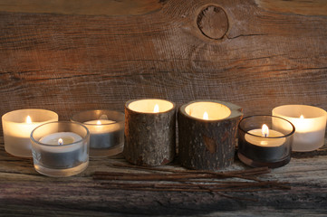 Burning candles on weathered wood