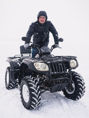 Naklejka premium Man in atv quad bike. Winter snow field