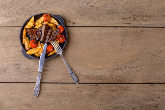 Sliced beef with potatos and tomatos