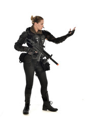 Naklejka premium full length portrait of female soldier wearing black tactical armour, holding a rifle gun, isolated on white studio background.