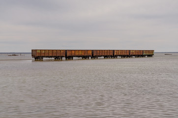 open railroad cars waiting for loading in brine at salt mining site Lake baskunchak, Astrakhan...