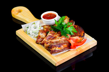 Fried grilled meats with vegetables on a black background