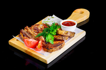 Fried grilled meats with vegetables on a black background