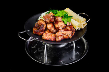 Fried grilled meats with vegetables on a black background