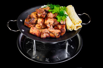 Fried grilled meats with vegetables on a black background