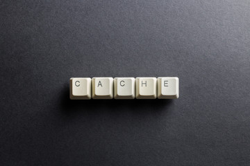 Word cache made using computer keyboard buttons on a black background. Compact disk. IT technology concept.