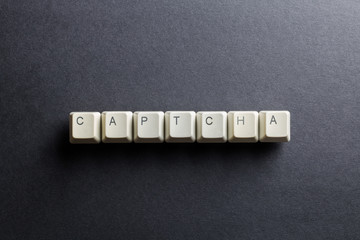 Word captcha made using computer keyboard buttons on a black background. Compact disk. IT technology concept.