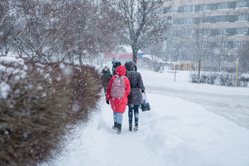 Fototapeta na wymiar People walking under the snow.