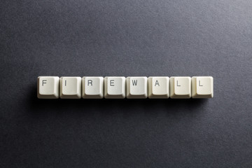 Word firewall made using computer keyboard buttons on a black background. Computer networks technological barrier. IT technology concept.