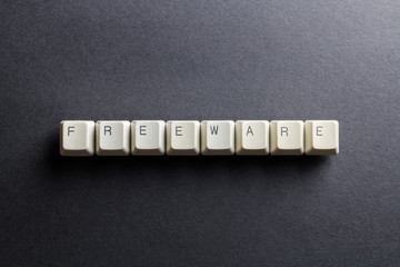 Word freeware made using computer keyboard buttons on a black background. No monetary cost free software. IT technology concept.
