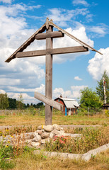 Wooden orthodox cross in russian village in summer sunny day