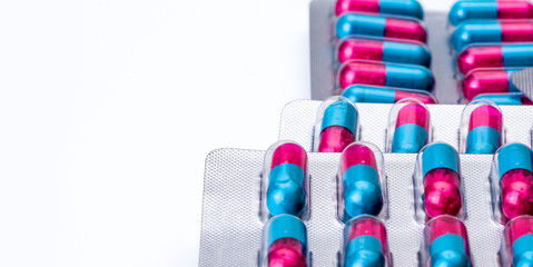 Colorful of blue, pink capsule with granule in side pills. Pills in blister pack on white...