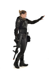 Fototapeta premium full length portrait of female soldier wearing black tactical armour, holding a rifle gun, isolated on white studio background.