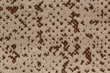 Speckled fabric background in light brown hue.