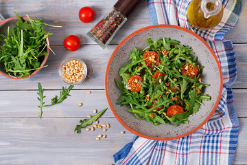 Dietary menu. Vegan cuisine. Healthy salad with arugula, tomatoes and pine nuts. Flat lay. Top view