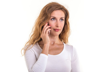 Fototapeta premium Beautiful caucasian woman in white t-shirt using smartphone. Studio shooting isolated on white