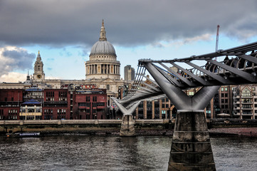Fototapeta na wymiar Millenium bridge view with St Paul’s Cathedral in the back and Thames river. Cloudy and cold winter day.