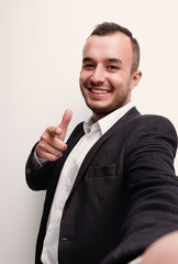 Happy successful businessman pointing on copy space