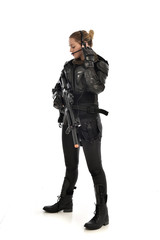 Fototapeta na wymiar full length portrait of female soldier wearing black tactical armour, holding a rifle gun, isolated on white studio background.