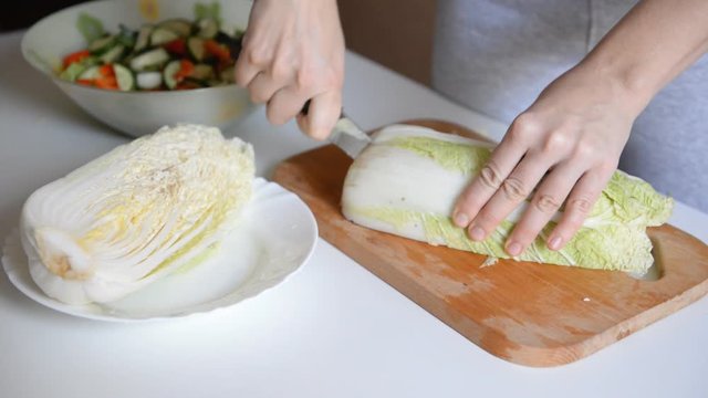 the chef cuts chinese cabbage for salad