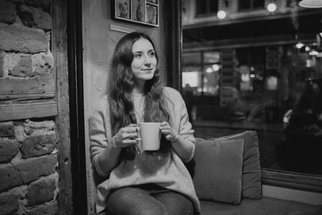 Beautiful girl with long hair drinks hot tea in the cafe. Riga Latvia