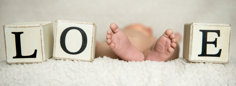 Children's feet. Tiny legs of a newborn baby Concept of a happy family. Beautiful conceptual image of motherhood.