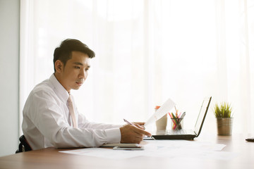 Business man working at office with laptop and documents on his desk