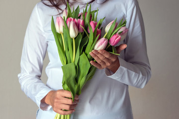 Spring bouquet of pink tulips in woman's hands