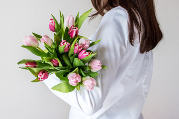 Spring bouquet of pink tulips in woman's hands