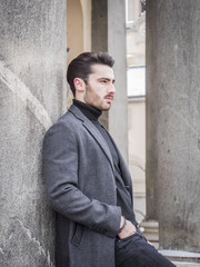 Fototapeta premium Handsome bearded young man outdoor in winter fashion, wearing black turtleneck sweater and woolen blazer jacket in city setting