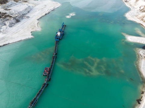 Aerial View Of The Long Boom Of A Suction Excavator In A Quartz Quarry For The Excavation Of White Sand.