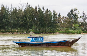 one old fishing boat anchored on the side of the river