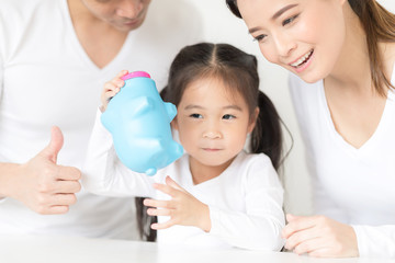 Parents are teaching daughter on saving money and financial planning.