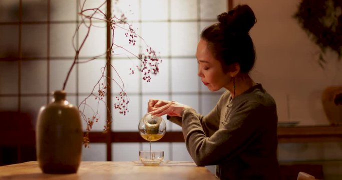 Japanese Female pouring green tea in traditional house, Kyoto, Japan