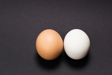 White and yellow egg on a black background. Close-up.