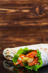 Delicious shawarma sandwich on wooden background