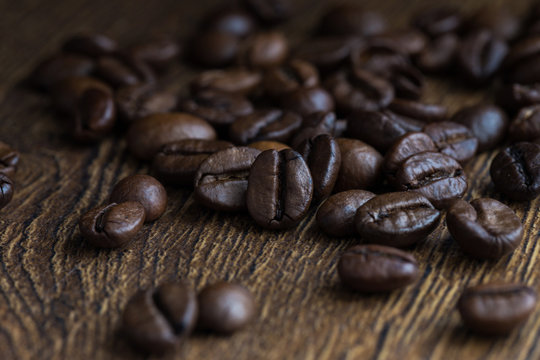 Texture of coffee beans on a wooden background close-up.