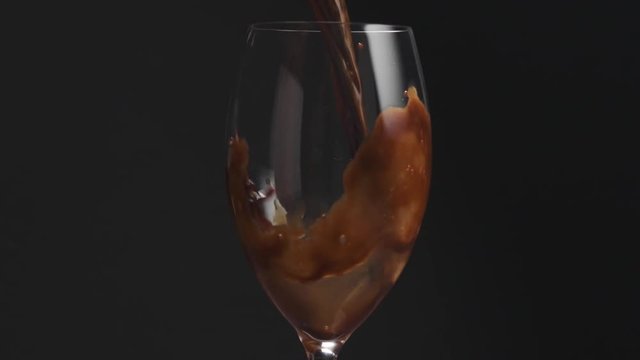 Slow motion closeup of pouring espresso into glass